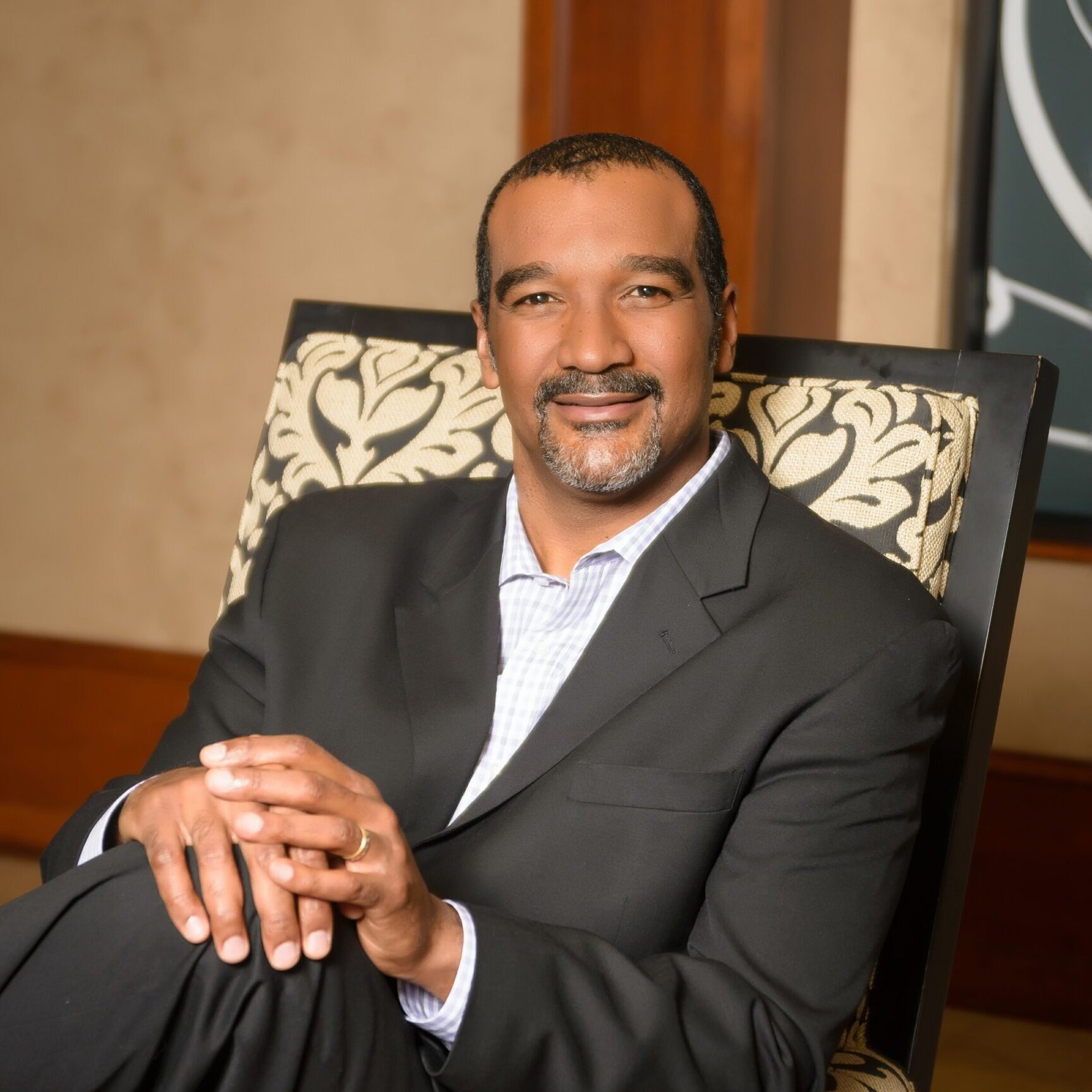 A man in a suit sitting on top of a chair.